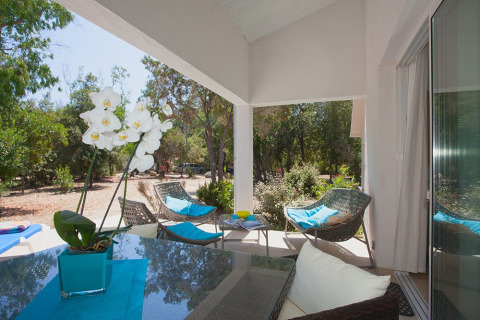 Terrazza coperta ai Camping Bagheera – Eco lodges Corsica, con arredi moderni e vista sulla natura verde.