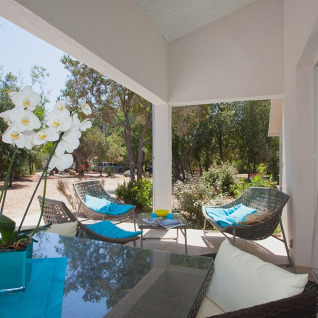 Terrazza coperta ai Camping Bagheera – Eco lodges Corsica, con arredi moderni e vista sulla natura verde.