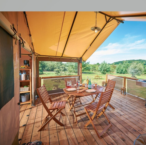 Terraza de glamping en Camping Bagheera – Eco lodges Córcega, con muebles de madera y vistas naturales al aire libre.