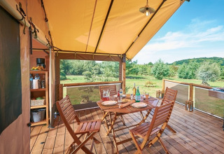 Terrasse glamping conviviale au Camping Bagheera – Eco lodges Corse, équipée de meubles en bois et vue sur la nature.