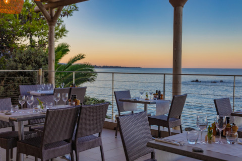 Terrazza ristorante all'aperto con vista sul mare al tramonto presso Camping Bagheera – Eco lodges Corsica.