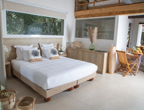 Habitación de glamping luminosa y moderna en Camping Bagheera – Eco lodges Corsica con gran ventana y decoración natural.