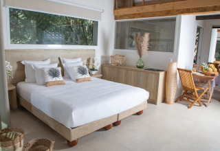 Bright, modern glamping room at Camping Bagheera – Eco lodges Corsica with large window and natural decor.