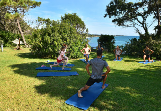 Outdoor-Yoga-Kurs im Camping Bagheera – Eco lodges Corsica mit Blick aufs Meer und grüne Umgebung.