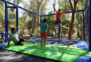 Familie nyder tid sammen på trampolin under deres ophold hos Camping Bagheera – Eco lodges Corsica.