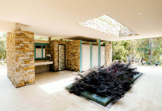 Sanitaires modernes en pierre avec plantes du Camping Bagheera – Eco lodges, harmonie avec la nature corse.