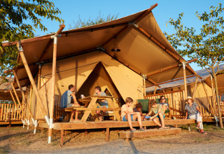 Familie entspannt sich auf der Terrasse eines Glamping-Zeltes bei Camping Nautic Almata – Glamping Costa Brava.