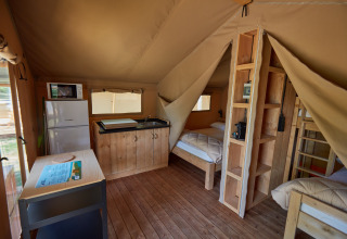 Interieur van een glamping-accommodatie op Camping Nautic Almata, Glamping Costa Brava, met keuken en bedden.