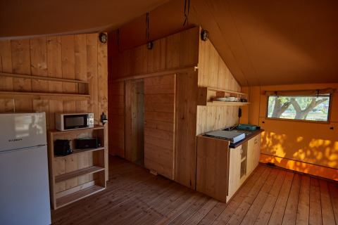 Interno in legno di sistemazione glamping al Camping Nautic Almata – Glamping Costa Brava con angolo cottura.