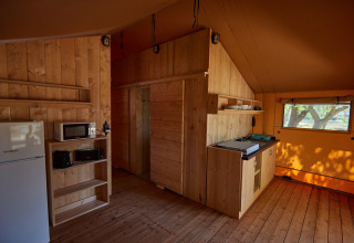 Træinteriør af et glampingophold på Camping Nautic Almata – Glamping Costa Brava med køkkenområde.