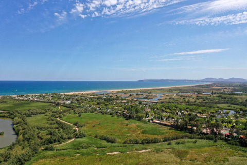 Luftfoto af Camping Nautic Almata – Glamping Costa Brava med grønne områder, strand og hav i baggrunden.