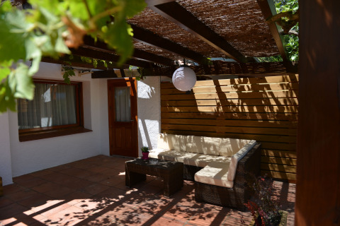 Gemütliche Terrasse mit Sitzgarnitur und Holzpergola bei Camping Nautic Almata – Glamping Costa Brava.
