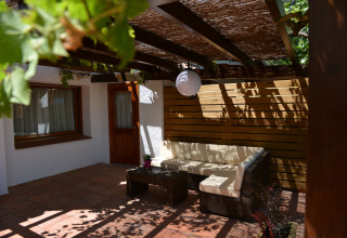 Acogedora terraza con zona de estar y pérgola en Camping Nautic Almata – Glamping Costa Brava.