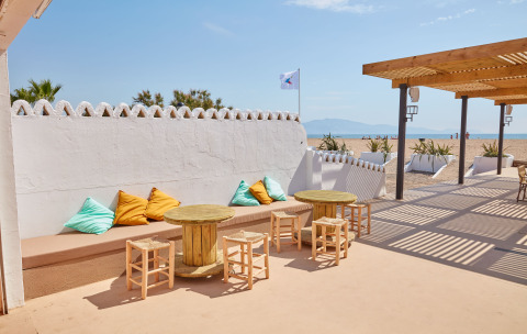 Udendørs loungeområde ved Camping Nautic Almata på Costa Brava med strandudsigt og farverige puder.