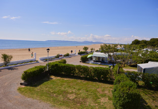 Vista del Camping Nautic Almata – Glamping Costa Brava con piazzole e aree verdi vicine alla spiaggia sabbiosa.