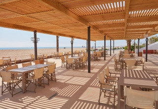 Area pranzo esterna con pergolato in legno presso Camping Nautic Almata – Glamping Costa Brava, Spagna.