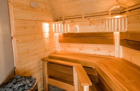 Interior view of a sauna with wooden benches and sauna stones at Camping Beringerzand - Finse Kota's Limburg.