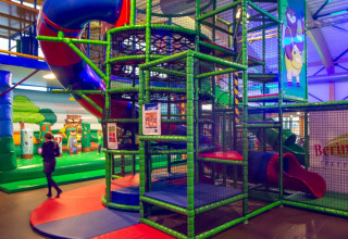 Aire de jeux intérieure avec structure à grimper, toboggans et tapis au Camping Beringerzand - Finse Kota's Limburg.