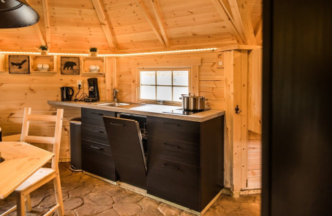 Hyggeligt træinteriør i Finse Kota på Camping Beringerzand med lille køkken og spisebord.