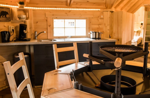 Vue intérieure d’un hébergement glamping Finse Kota au Camping Beringerzand, intérieur bois et grill.