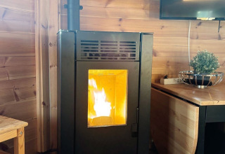 Moderne houtkachel in houten hut bij Camping Beringerzand - Finse Kota's Limburg, gezellige glamping.