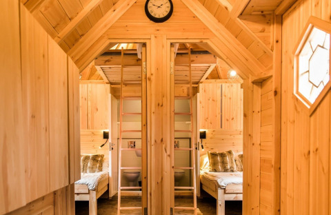 Interior view of glamping accommodation Camping Beringerzand - Finse Kota's Limburg with wooden decor and beds.