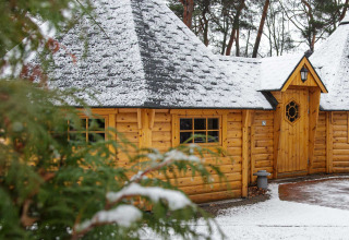 Finse Kota glampingaccommodatie met sneeuw bij Camping Beringerzand in Limburg, omgeven door bos en rust.
