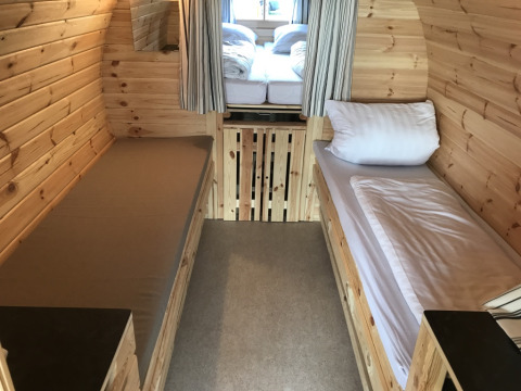 Glampingindkvartering med træinteriør og enkeltsenge hos Camping Pilsensee - Wijnvaten Beieren.