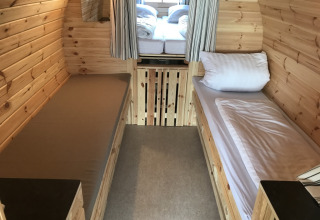 Glamping-Unterkunft mit Holzwänden und Einzelbetten bei Camping Pilsensee - Wijnvaten Beieren.