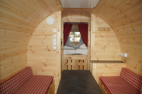 Innenansicht einer besonderen Weinfass-Glampingunterkunft bei Camping Pilsensee - Wijnvaten Beieren mit Bett.