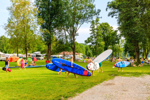 Mensen kamperen en dragen supboards bij Camping Pilsensee - Wijnvaten Beieren op een zonnige zomerdag.