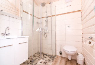 Moderne badkamer in glamping accommodatie bij Vakantiepark Ostseecamping Zierow, Duitsland, met douche.