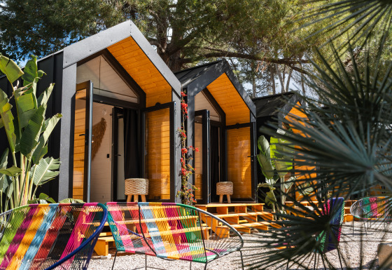 Kleurrijke glampingaccommodatie met moderne hutten en stoelen bij Camping Parco Ibiza by San Antonio, Ibiza.