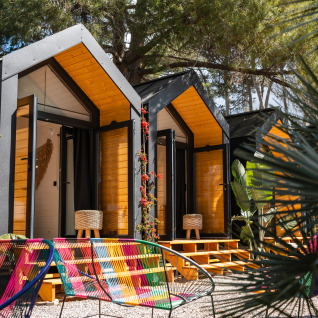 Hébergements glamping colorés avec cabanes modernes au Camping Parco Ibiza by San Antonio, à Ibiza, Espagne.