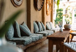 Buitenlounge bij Camping Parco Ibiza by San Antonio - Glamping Ibiza met kussens en houten meubels.