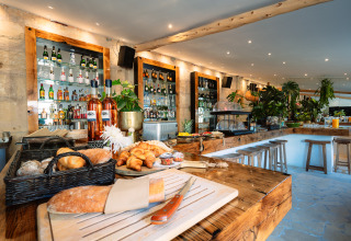 Gezellige bar bij Camping Parco Ibiza by San Antonio - Glamping Ibiza met brood, croissants en flessen.