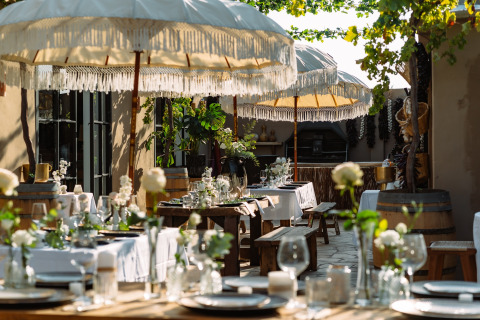 Buitenrestaurant met witte parasols en sfeervolle tafels bij Camping Parco Ibiza by San Antonio - Glamping Ibiza.