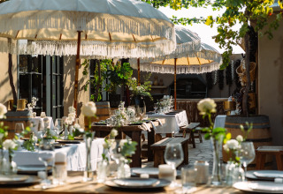 Buitenrestaurant met witte parasols en sfeervolle tafels bij Camping Parco Ibiza by San Antonio - Glamping Ibiza.