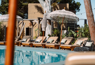 Buitenzwembad met ligbedden, parasols en veel groen bij Camping Parco Ibiza by San Antonio - Glamping Ibiza.