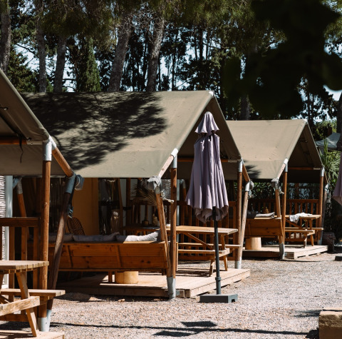 Glamping accommodatie met tenten en buitenzitplaatsen bij Camping Parco Ibiza by San Antonio - Glamping Ibiza.