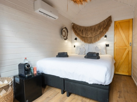 Glamping-accommodatie bij Camping Parco Ibiza by San Antonio met comfortabel bed en sfeervolle aankleding.