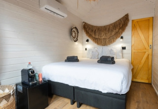 Glamping-accommodatie bij Camping Parco Ibiza by San Antonio met comfortabel bed en sfeervolle aankleding.