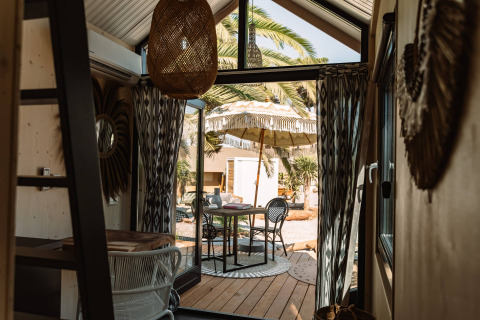 Binnenaanzicht van glampingaccommodatie bij Camping Parco Ibiza bij San Antonio met terras en parasol.