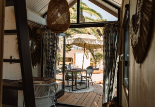 Binnenaanzicht van glampingaccommodatie bij Camping Parco Ibiza bij San Antonio met terras en parasol.