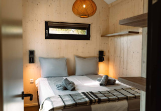 Slaapkamer in glamping-accommodatie met tweepersoonsbed en houten muren bij Camping Parco Ibiza nabij San Antonio.