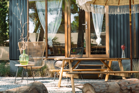 Buitenruimte bij Camping Parco Ibiza by San Antonio - Glamping Ibiza met tafels, stoelen en parasol.