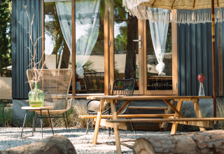 Buitenruimte bij Camping Parco Ibiza by San Antonio - Glamping Ibiza met tafels, stoelen en parasol.