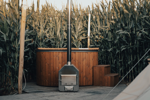 Alojamiento glamping con bañera de madera y terraza, rodeado de maizales en Glamping La Ferme, Flandes Occidental.