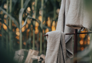 Serviettes douces suspendues en plein air avec coucher de soleil chez Glamping La Ferme - Glampingtenten West-Vlaanderen.