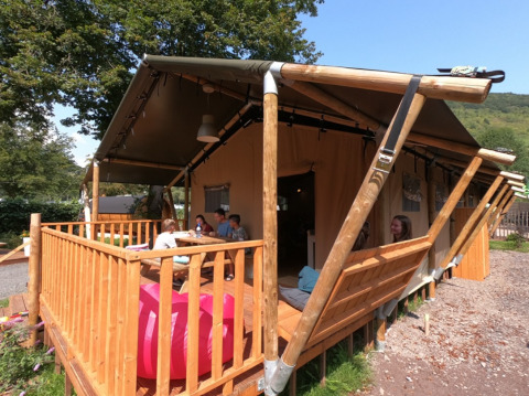 Glamping-Unterkunft bei Camping Alf - Safaritenten Rijnland-Palts mit Gästen auf der Holzterrasse.